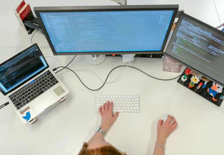 Mani di donna alla tastiera davanti al computer